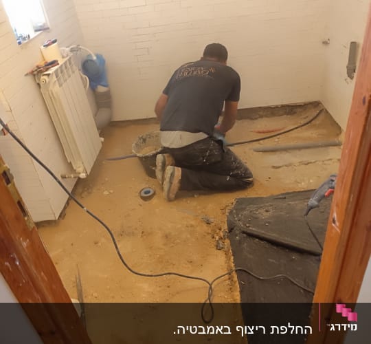אדם עובד על רצפת חדר בשיפוץ
